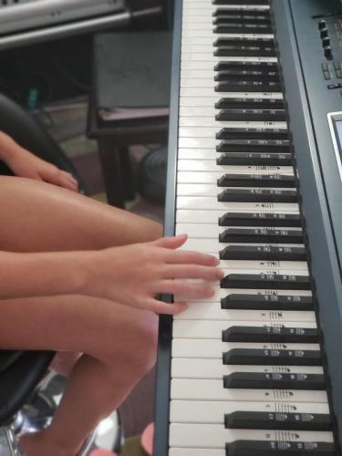 Student playing piano, hands on the keys